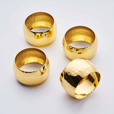 Set of four elegant gold napkin rings with a hammered finish.
