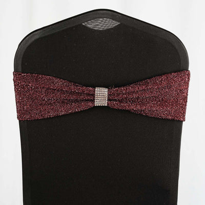 Burgundy sequin chair sash with rhinestone clasp on black chair.