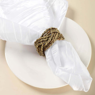 Decorative woven napkin ring on a white plate with a folded napkin.
