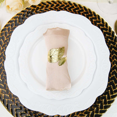 Elegant napkin with gold leaf ring on a decorative plate setting.