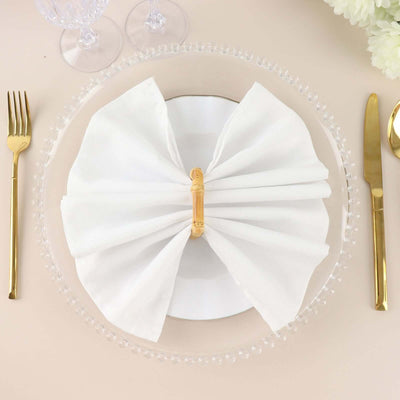 Elegant white napkin tied with bamboo ring on a decorative plate setting.
