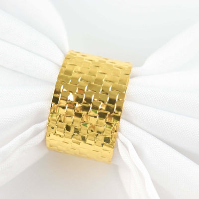 Gold woven napkin ring on white fabric