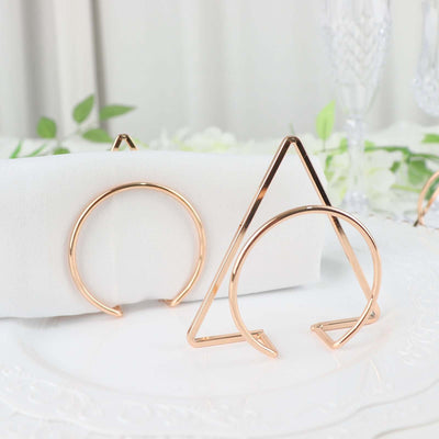 Rose gold geometric napkin holders on a decorative plate.