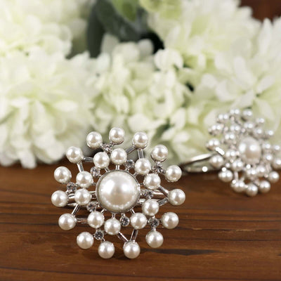 Elegant pearl and silver brooch on a wooden surface.