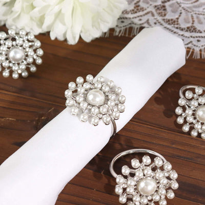 Elegant silver pearl napkin ring on a white napkin.