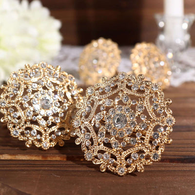 Elegant gold and crystal brooches displayed on a rustic wooden surface.