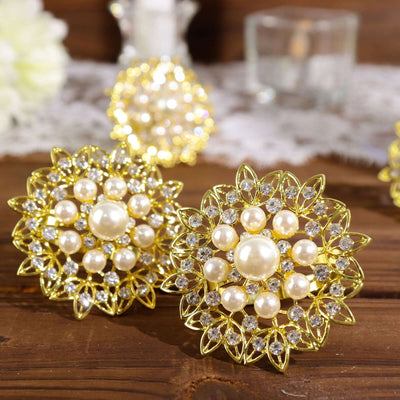 Gold and pearl floral brooches on a wooden surface.