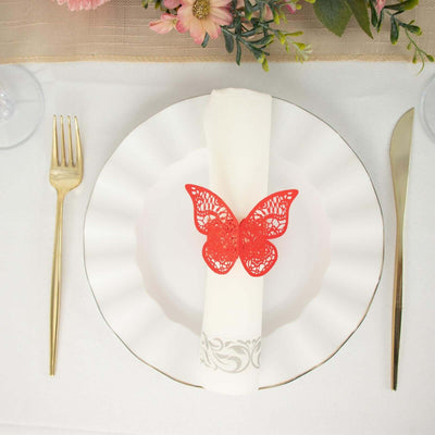 Red lace butterfly napkin holder on a white plate, elegantly set for dining.