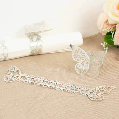 Silver lace butterfly bookmark on a textured surface.