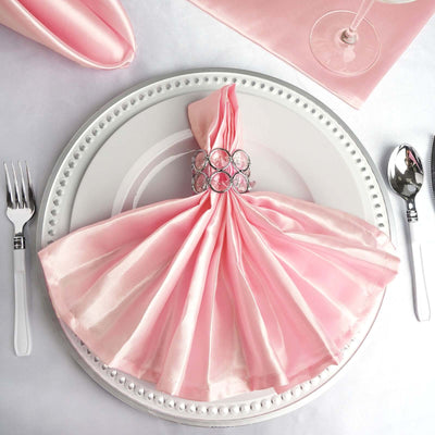 Elegant pink napkin dress on a decorative plate for a stylish dining experience.