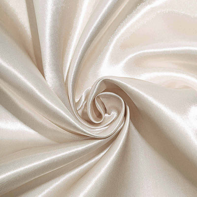Silky beige fabric in a swirling pattern showing smooth texture.