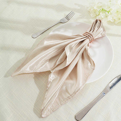 Elegant beige napkin tied with a ring on a white plate, set on a light tablecloth.
