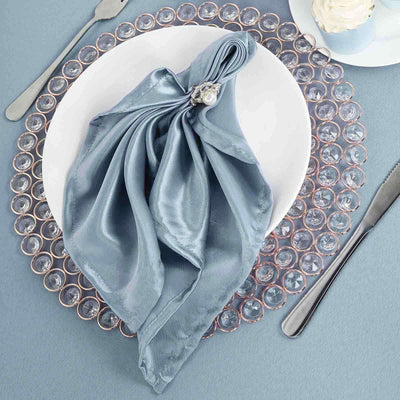 Elegant blue satin napkin elegantly arranged on a decorative plate.