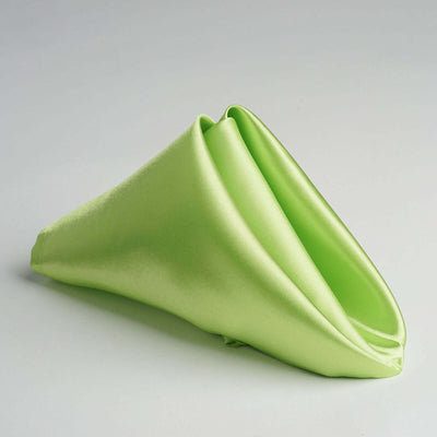 Green satin fabric draped elegantly on a flat surface.