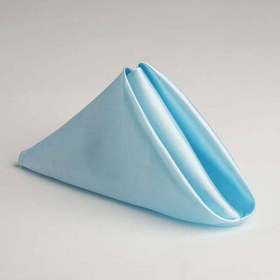 Blue fabric napkin elegantly folded in a cone shape.