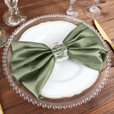 Elegant green napkin bow on a decorative plate with crystal holder.