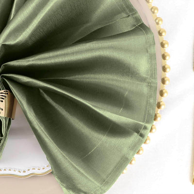 Green satin fabric draped elegantly on a decorative surface.