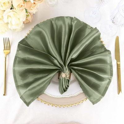Elegant green napkin folded with a decorative ring on a beautifully set table.