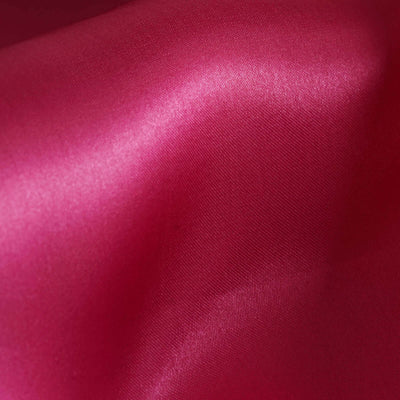 Glossy magenta fabric texture close-up showcasing soft sheen and smooth surface.