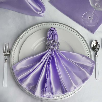 Elegant purple satin napkin artfully arranged on a white plate with silver accents.