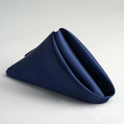 Navy blue fabric napkin folded in an elegant triangular shape