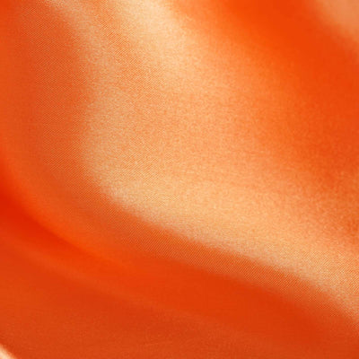 Close-up of smooth orange satin fabric texture.