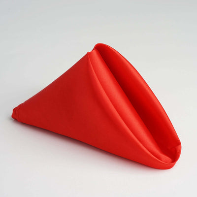 Red fabric napkin folded in a cone shape.