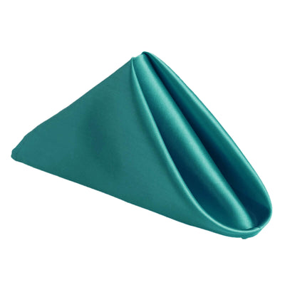 Teal fabric napkin folded in a triangular shape