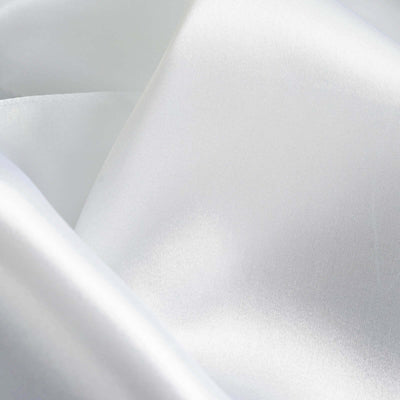 Close-up of soft, shiny white satin fabric texture.
