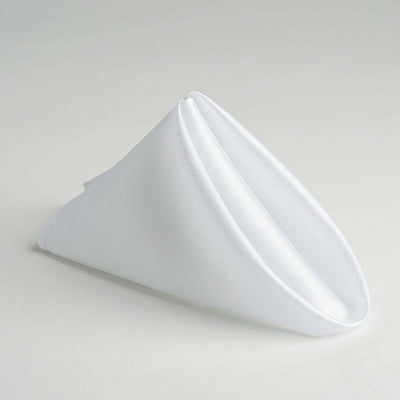 White fabric napkin in a folded cone shape on a plain background.