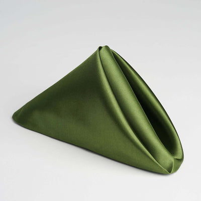 Green fabric napkin elegantly folded in a triangular shape.