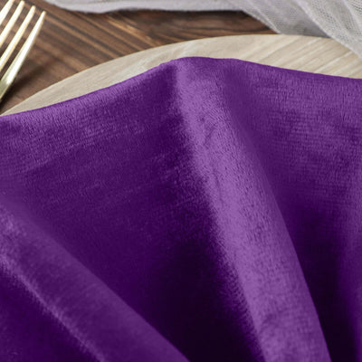 Purple satin napkin draped elegantly on a wooden table.