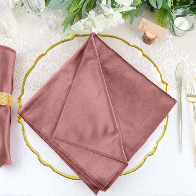 Rose-colored napkin elegantly folded on a decorative gold plate.