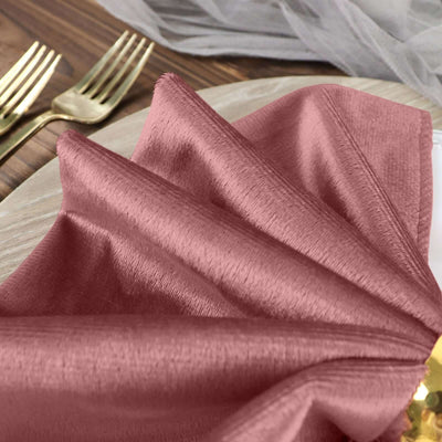 Rose pink fabric napkin elegantly folded on a dining plate.