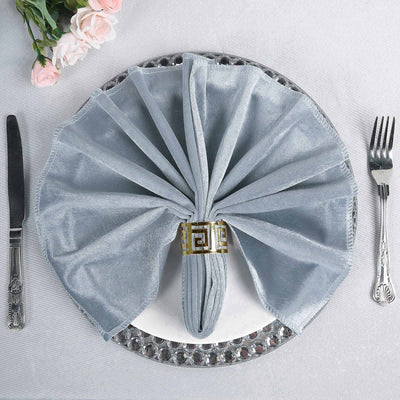 Elegant gray napkin folded stylishly on a decorative plate with cutlery.