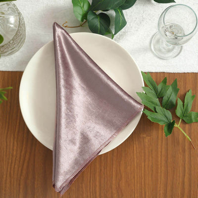 Elegant mauve satin napkin neatly folded on a plate with greenery