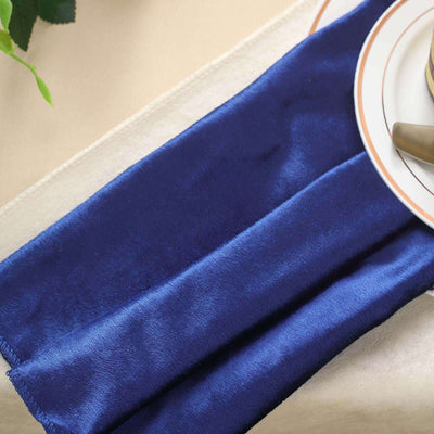 Navy blue satin table runner elegantly draped on a dining table.