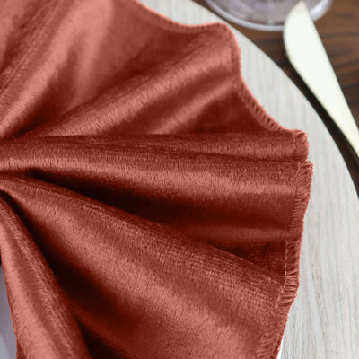Rust-colored satin napkin elegantly arranged on a dining plate.