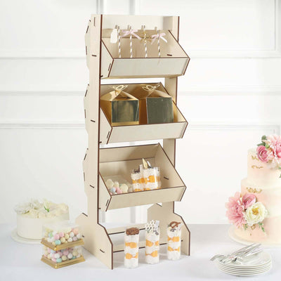 Wooden dessert display stand with treats and cake in a styled setup.