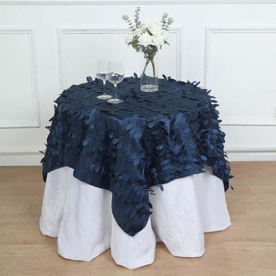Navy blue textured tablecloth draped over a round table with glasses and flowers.