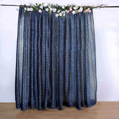 Glittery navy blue curtains with floral accents on top.