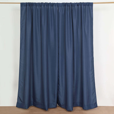 Navy blue curtains hanging on a rod in a studio setting