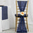 Gold chiavari chair draped with navy sequin sash and flower accent.