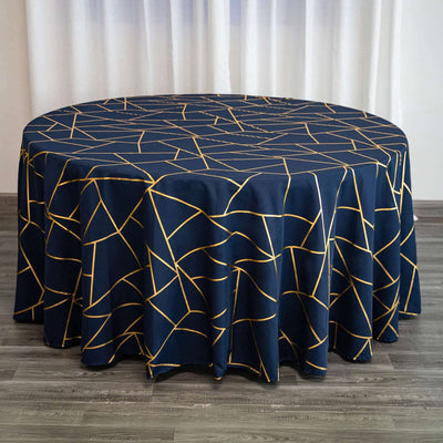 Navy round tablecloth with geometric gold pattern on a wooden surface.