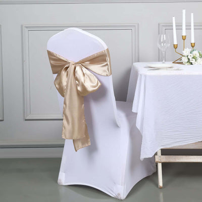 White chair cover with gold satin bow at elegant table setting.
