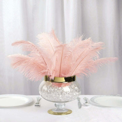 Pink feather centerpiece in a glass vase with crystals on a table setting.