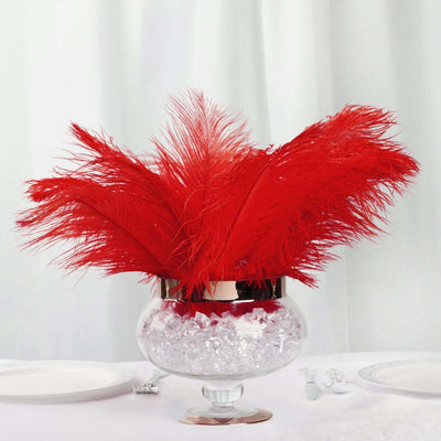 Red feather centerpiece in a glass vase with ice crystals.