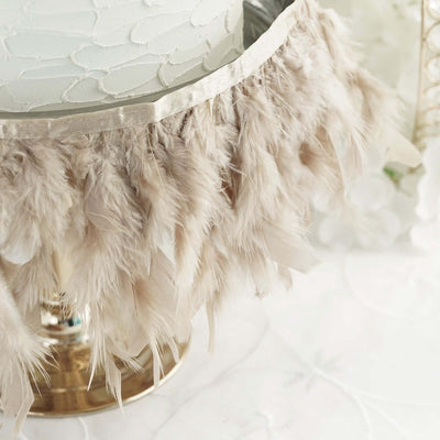 Feathered cake stand with elegant beige trim and gold base.