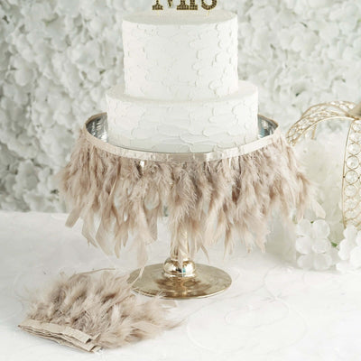 Elegant white wedding cake with feathered skirt decoration.