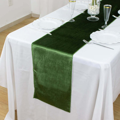 Green velvet table runner on a white table setting.